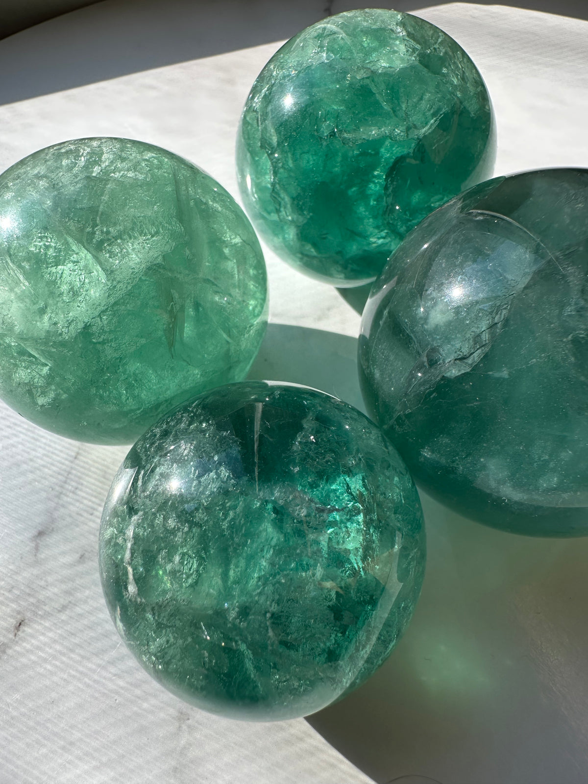 Polished Green Fluorite sphere close-up with translucent mineral zoning