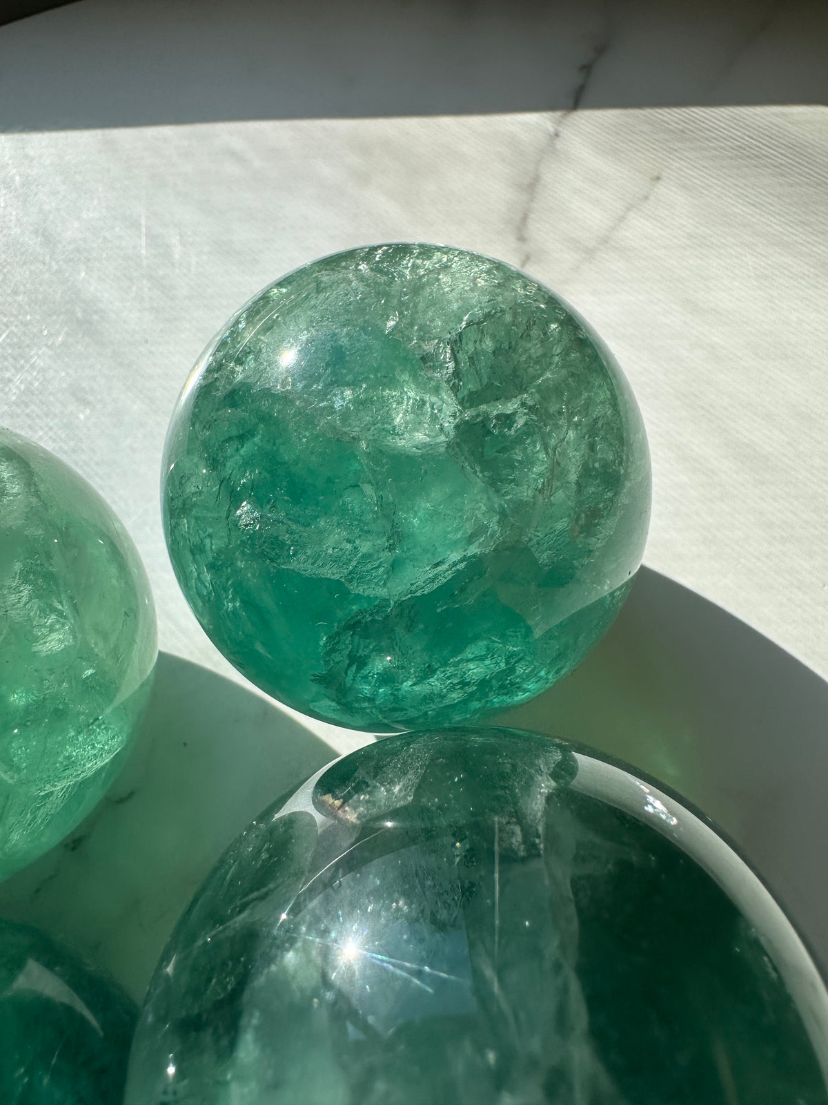 Green Fluorite crystal ball showing natural colour variation and polish