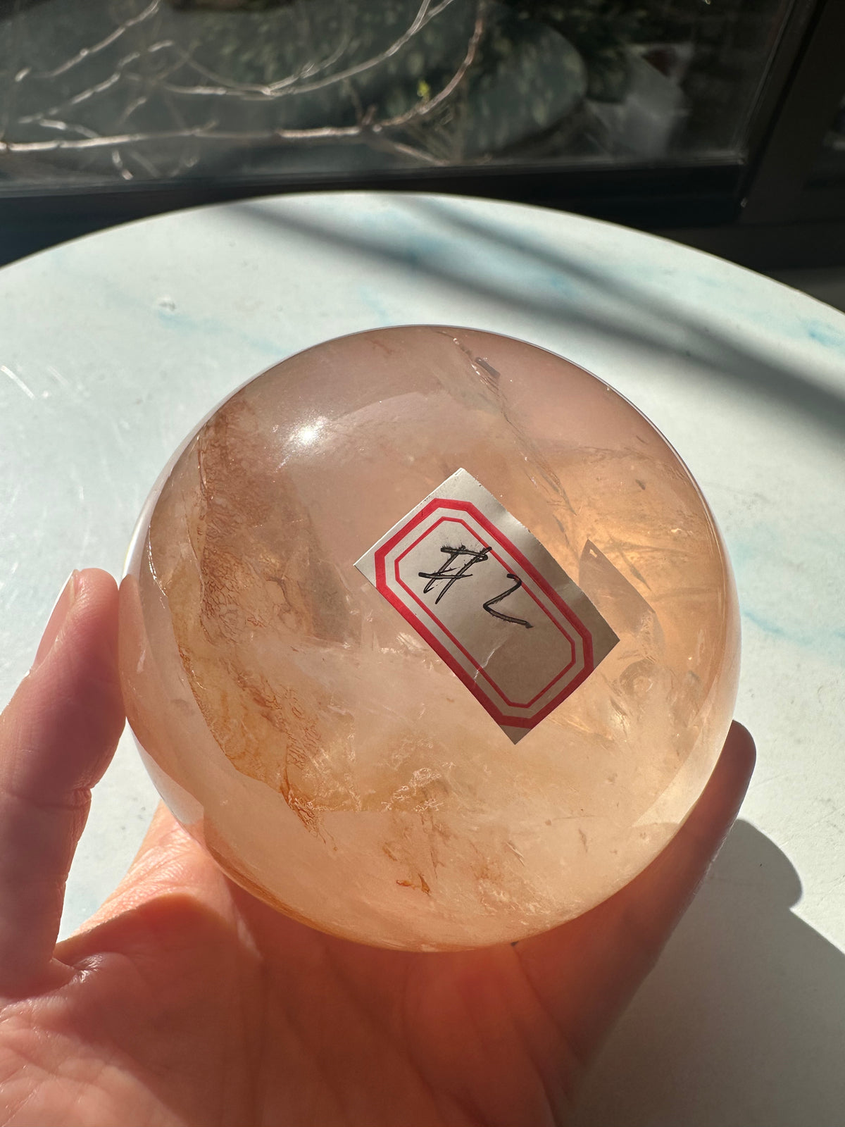 Fire Quartz sphere #2 showing red hematite inclusions and internal quartz veils, alternate view 2
