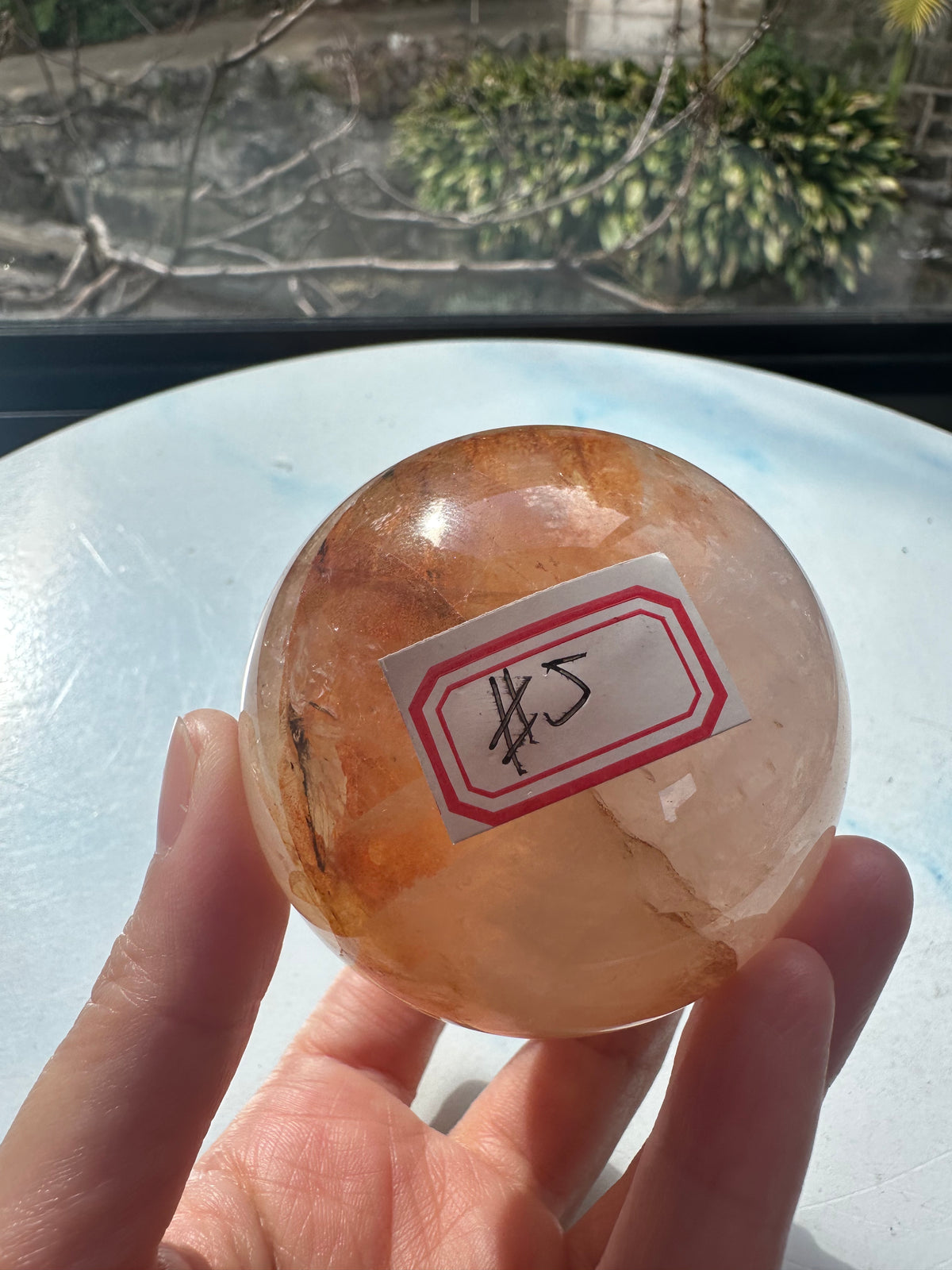 Fire Quartz sphere #5 showing red hematite inclusions and internal quartz veils, alternate view 2