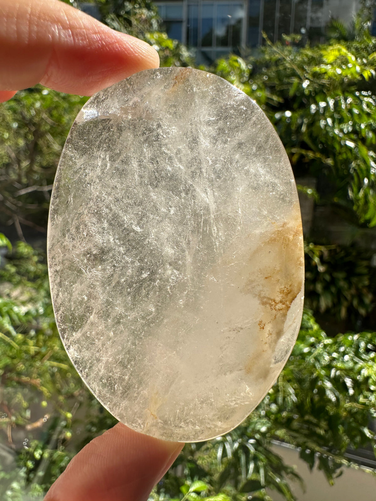 Smooth Clear Quartz palm stone with internal veils