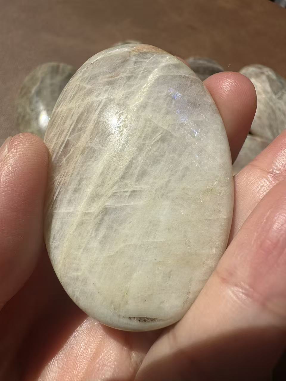 5–6cm Rainbow Moonstone palm stone photographed from alternate angle