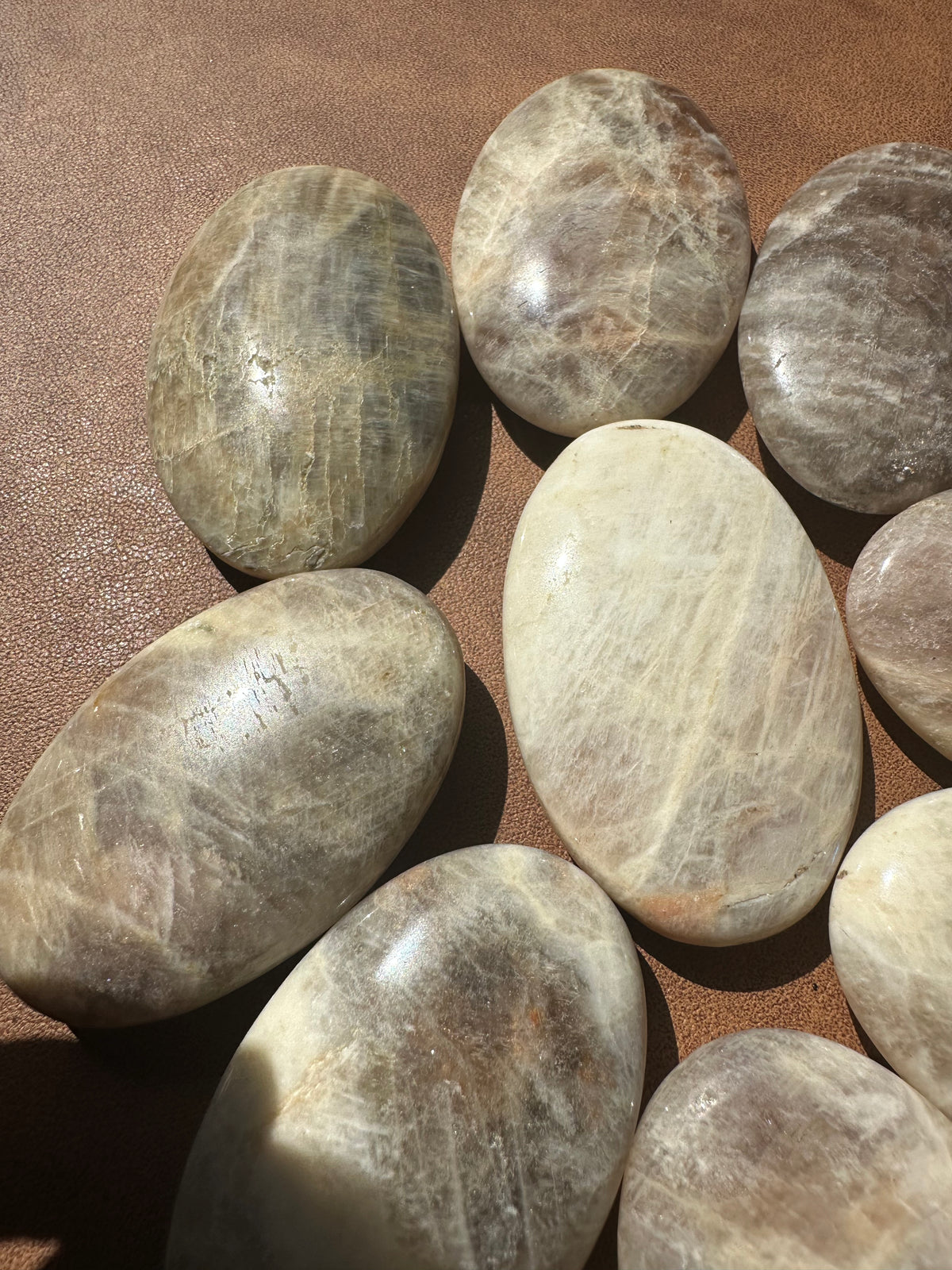 Natural Rainbow Moonstone palm stone with cream-white base and colourful flash