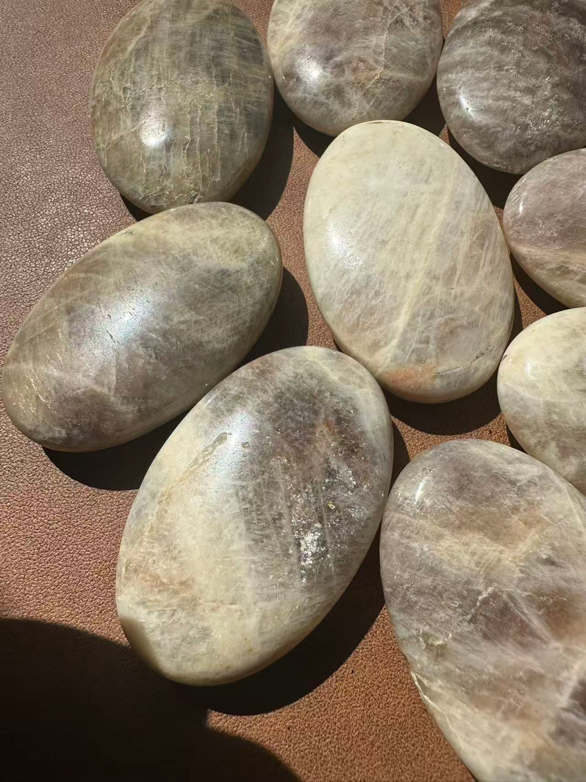Rainbow Moonstone palm stone close-up showing natural inclusions and polished finish