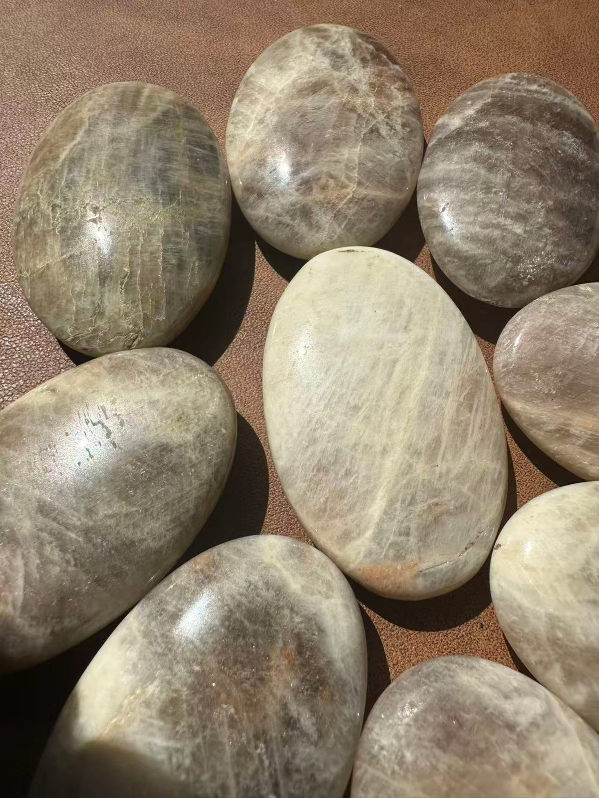 Polished Rainbow Moonstone crystal palm stone showing white and cream colour variation