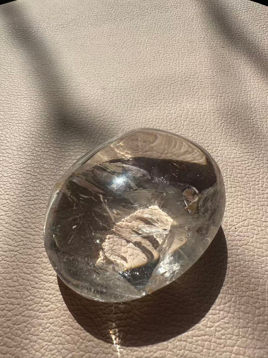  High-clarity Clear Quartz palm stone 202g with vivid internal rainbows and rare feather-like pattern by Moon Rituals.