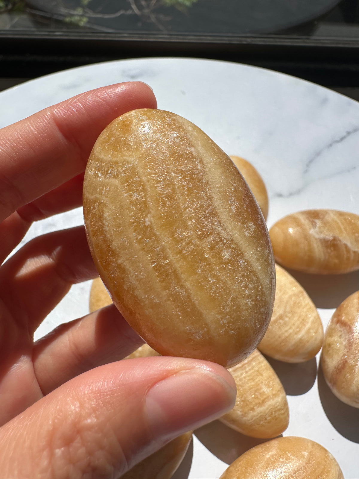 Natural Yellow Calcite polished palm stone close view