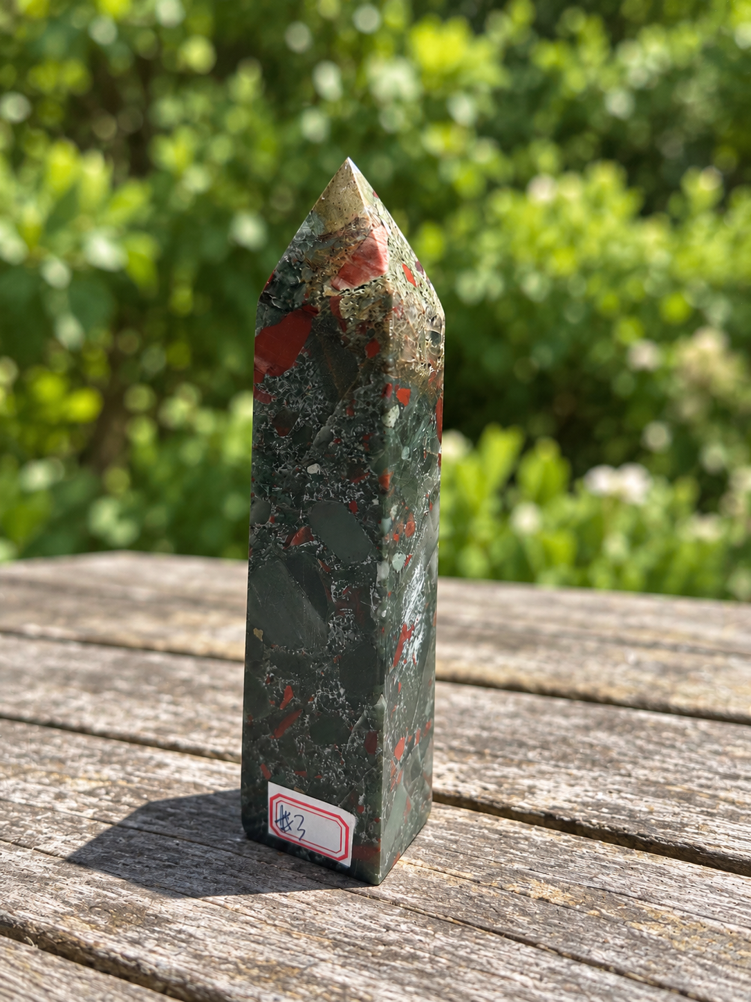 Three-quarter view of No.3 African bloodstone point showing red patches beneath its textured cream and tan tip