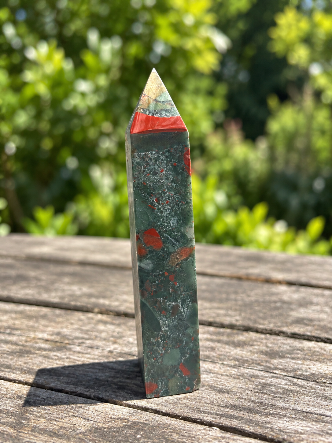 Narrow red-banded face of the 480g African bloodstone point with grey-green stone and small red markings