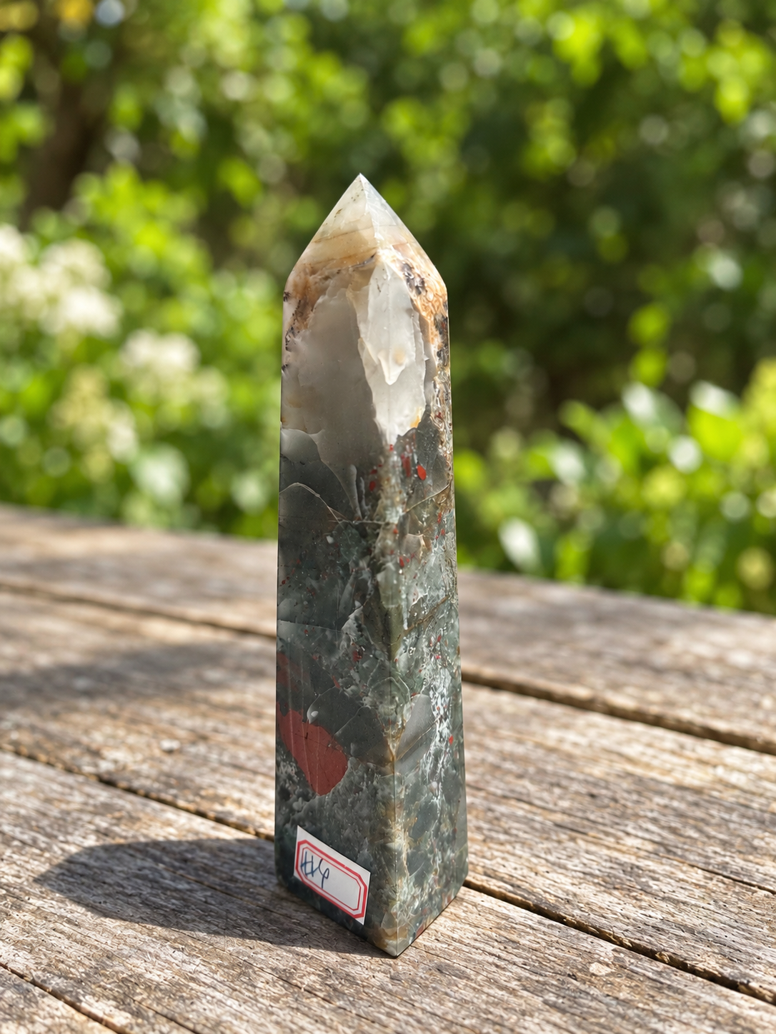 Angled view of exact No.4 bloodstone tower with cloudy cream-grey upper section, tan seam, fine pale veins and muted red patch near the base.
