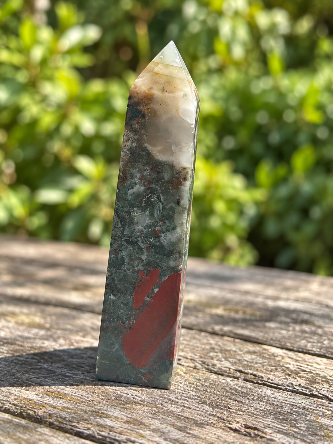 Reverse face of exact No.4 bloodstone tower with elongated dusty-red patches, grey-green stone and pale veins beneath the cloudy light tip.