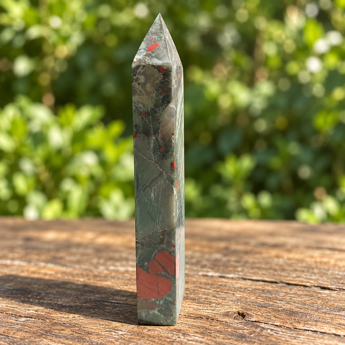 Narrow side of exact No.5 tower with red patches near the base, pale inclusions and fine light veins.