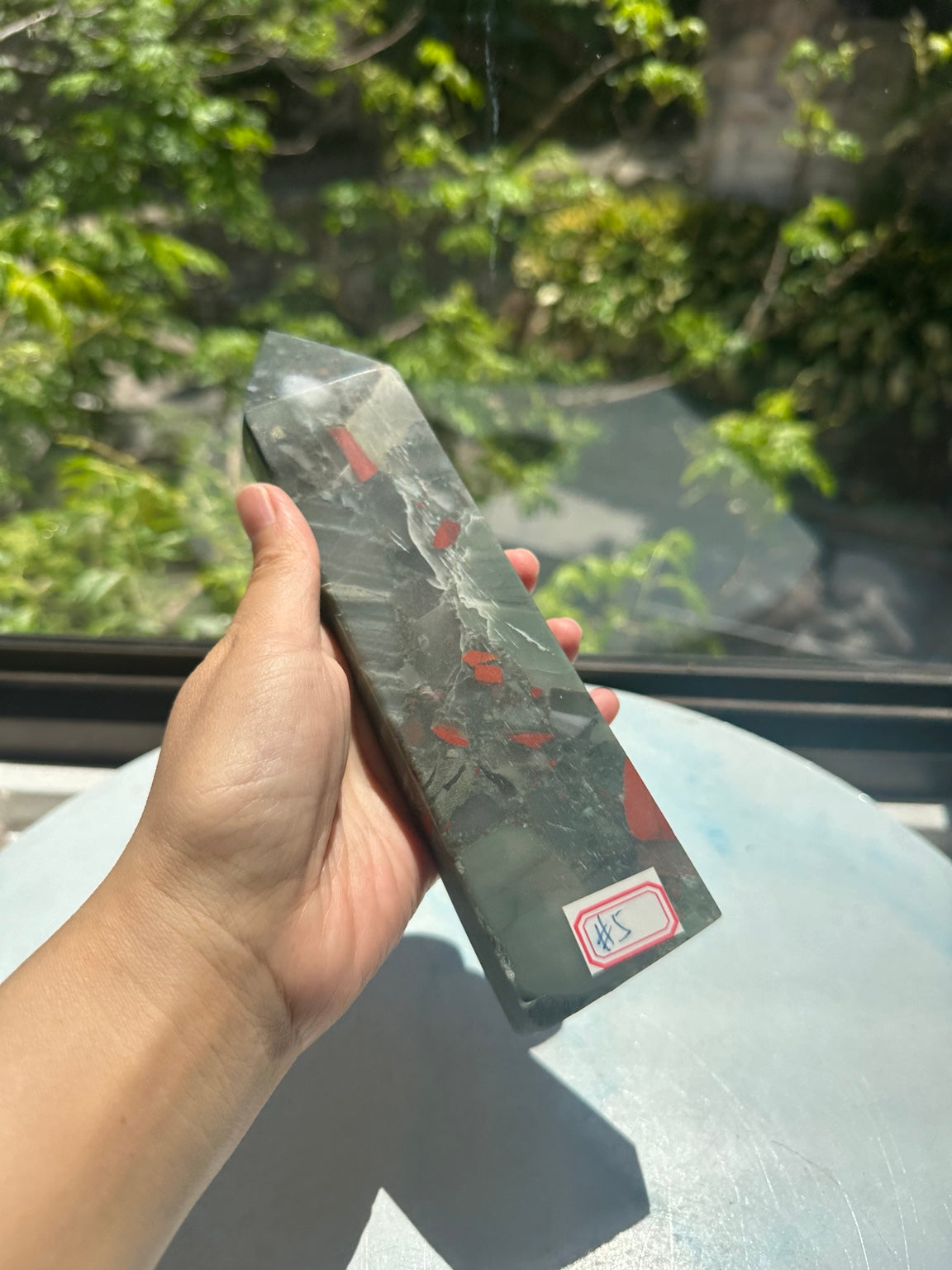 Unedited original hand-held photograph of exact No.5 bloodstone tower, showing its scale and identifying number label.