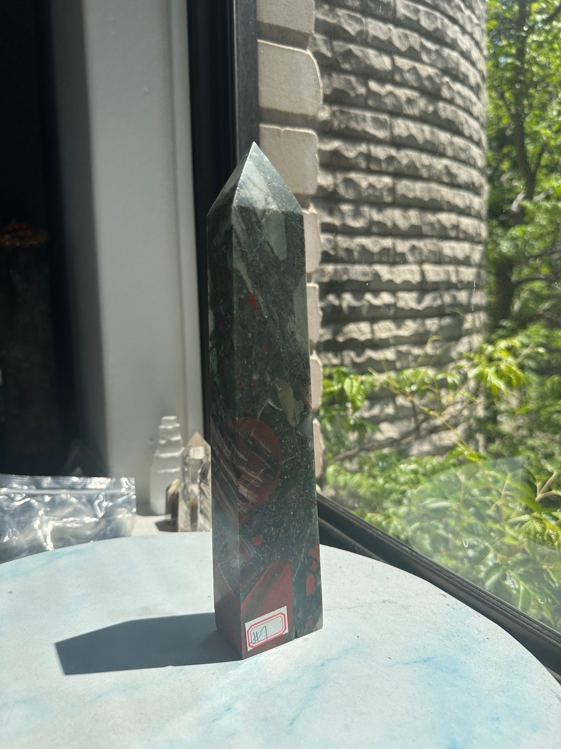 Original window-light photograph of No.7 bloodstone tower with grey-green body, muted brick-red patches and visible surface finish.