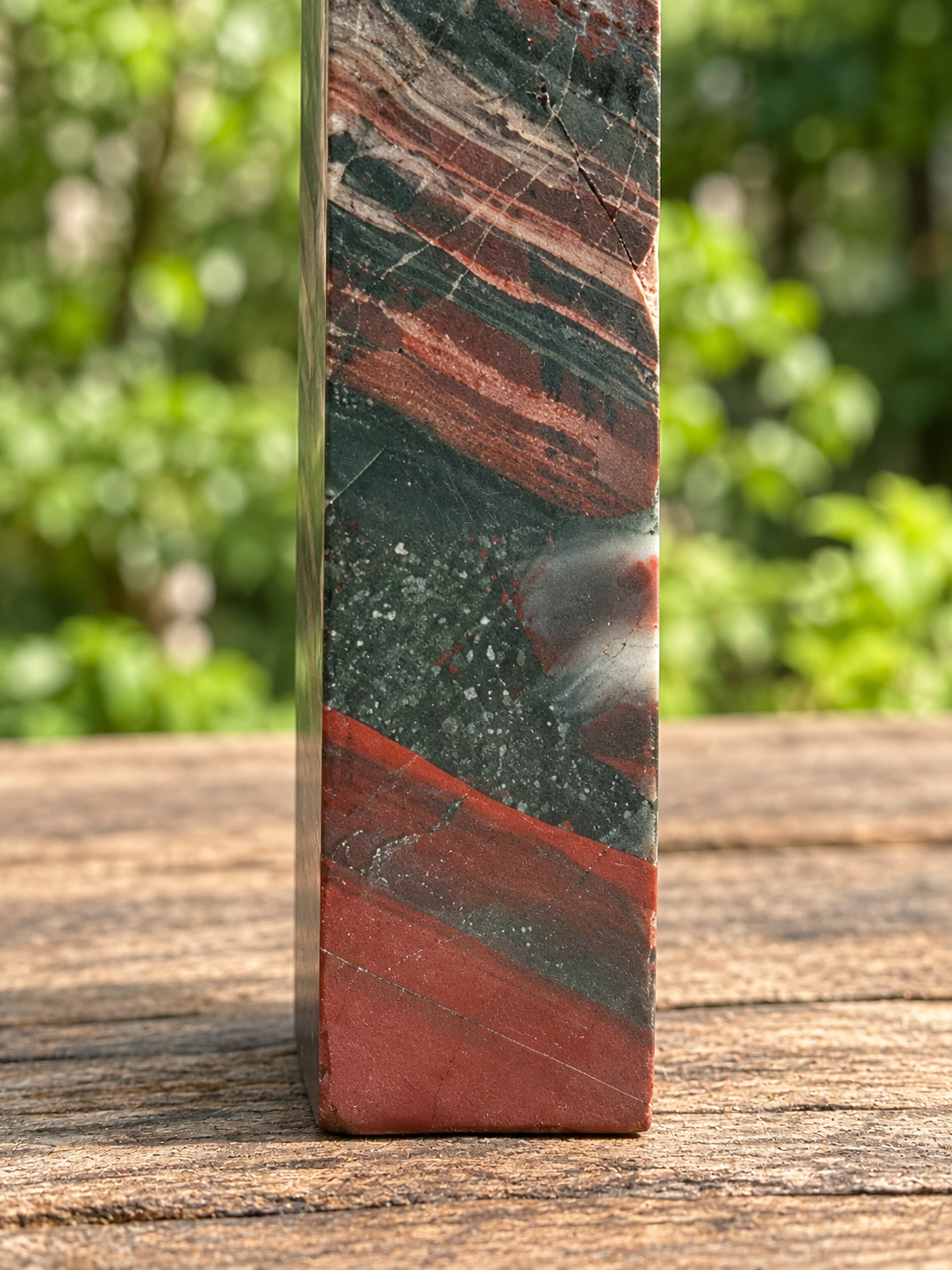 Close detail of No.7 bloodstone tower lower face showing pale diagonal lines, red-brown bands and visible surface texture.