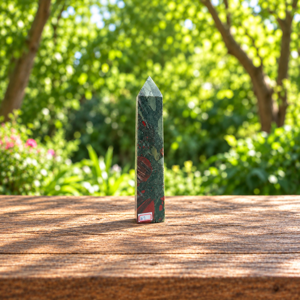 Front view of exact No.7 African bloodstone tower with red patches and number label on a wooden table.