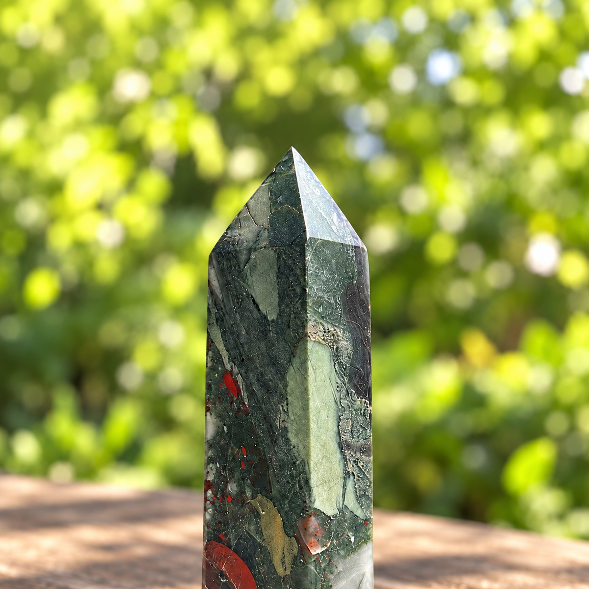 Upper detail of No.7 bloodstone tower showing pointed facets, pale sage marking and small natural mineral cavities.