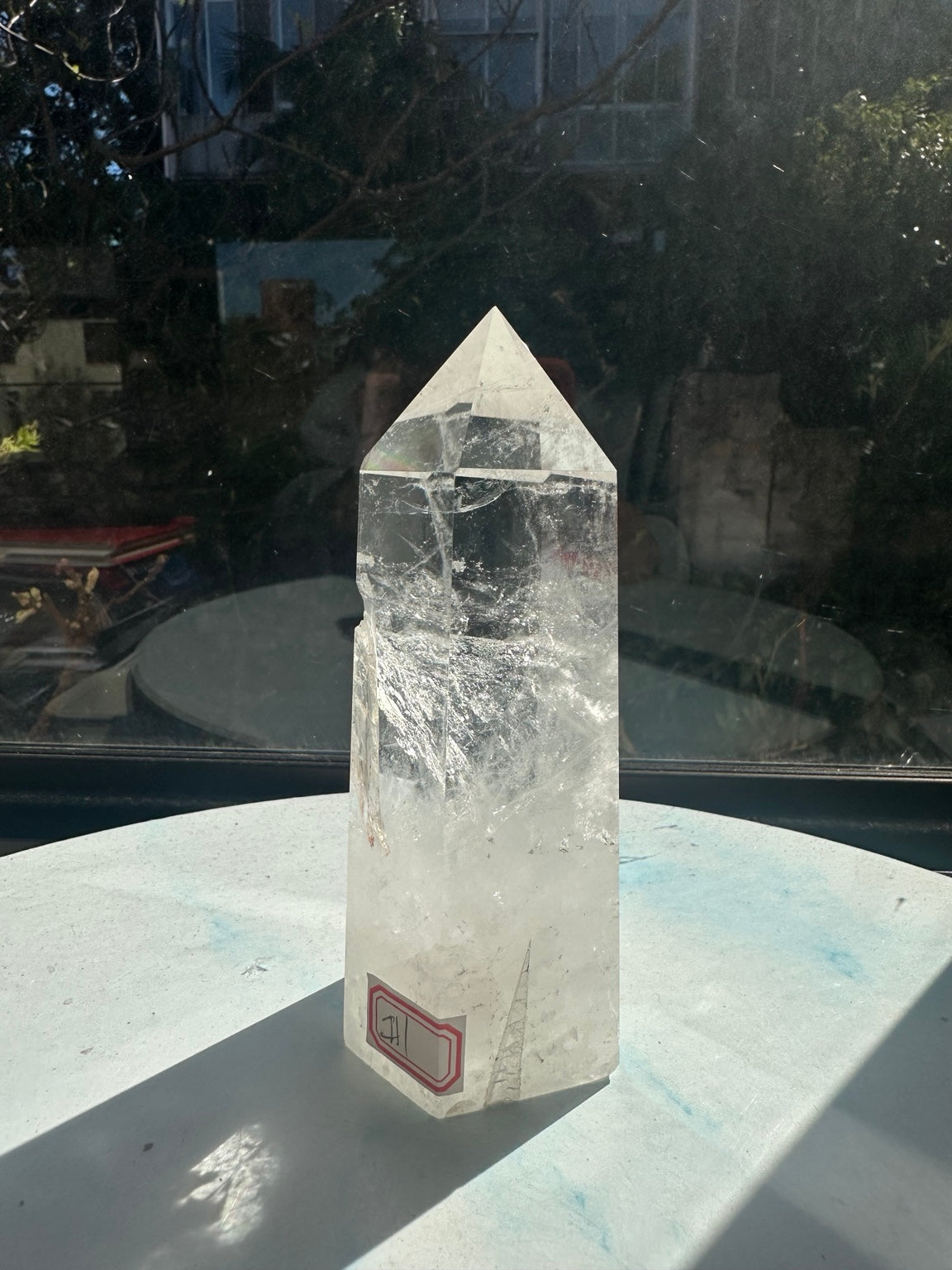 Angled view of the quartz tower showing a transparent pointed upper section, internal lines and milky white base.