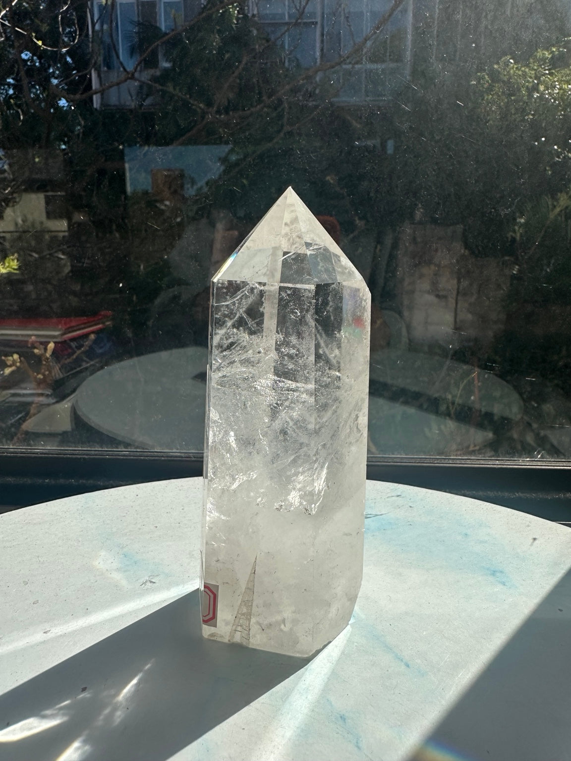 Narrow view of the six-sided quartz point showing its tip, polished edges and textured clear upper section.