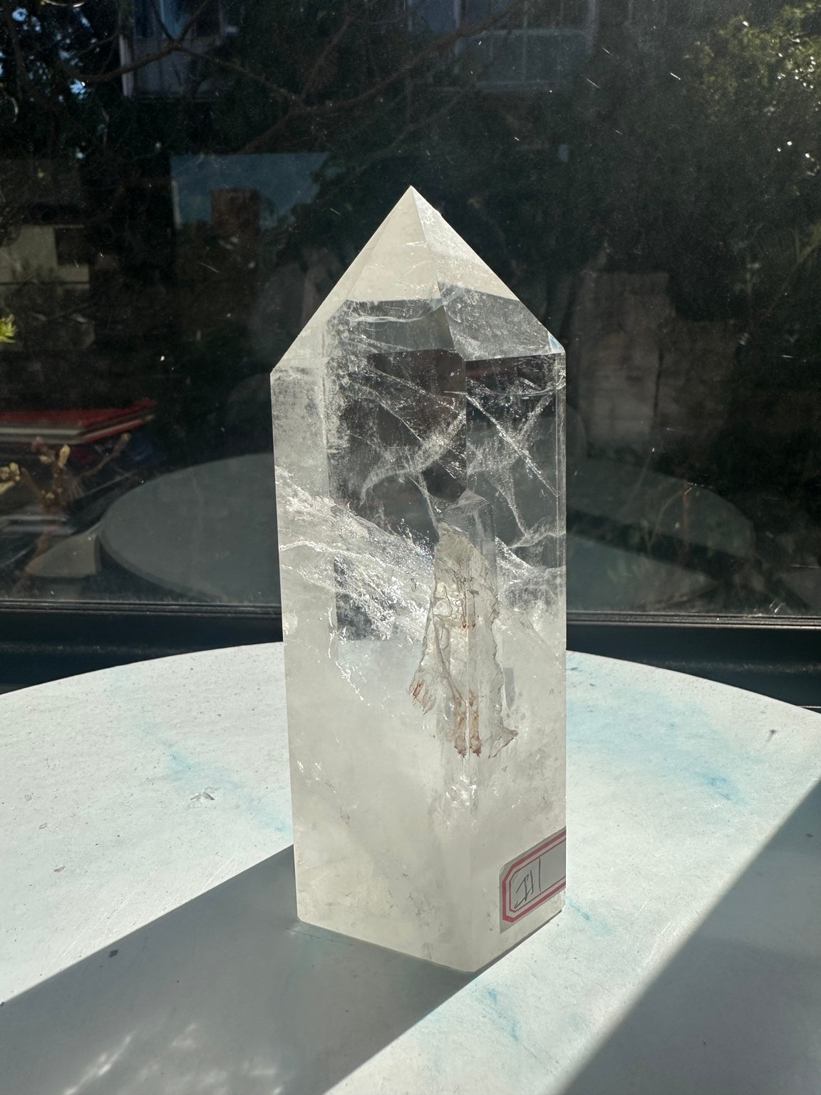 Rear angle of the exact quartz tower, with intersecting internal fracture lines and the label at its lower edge.