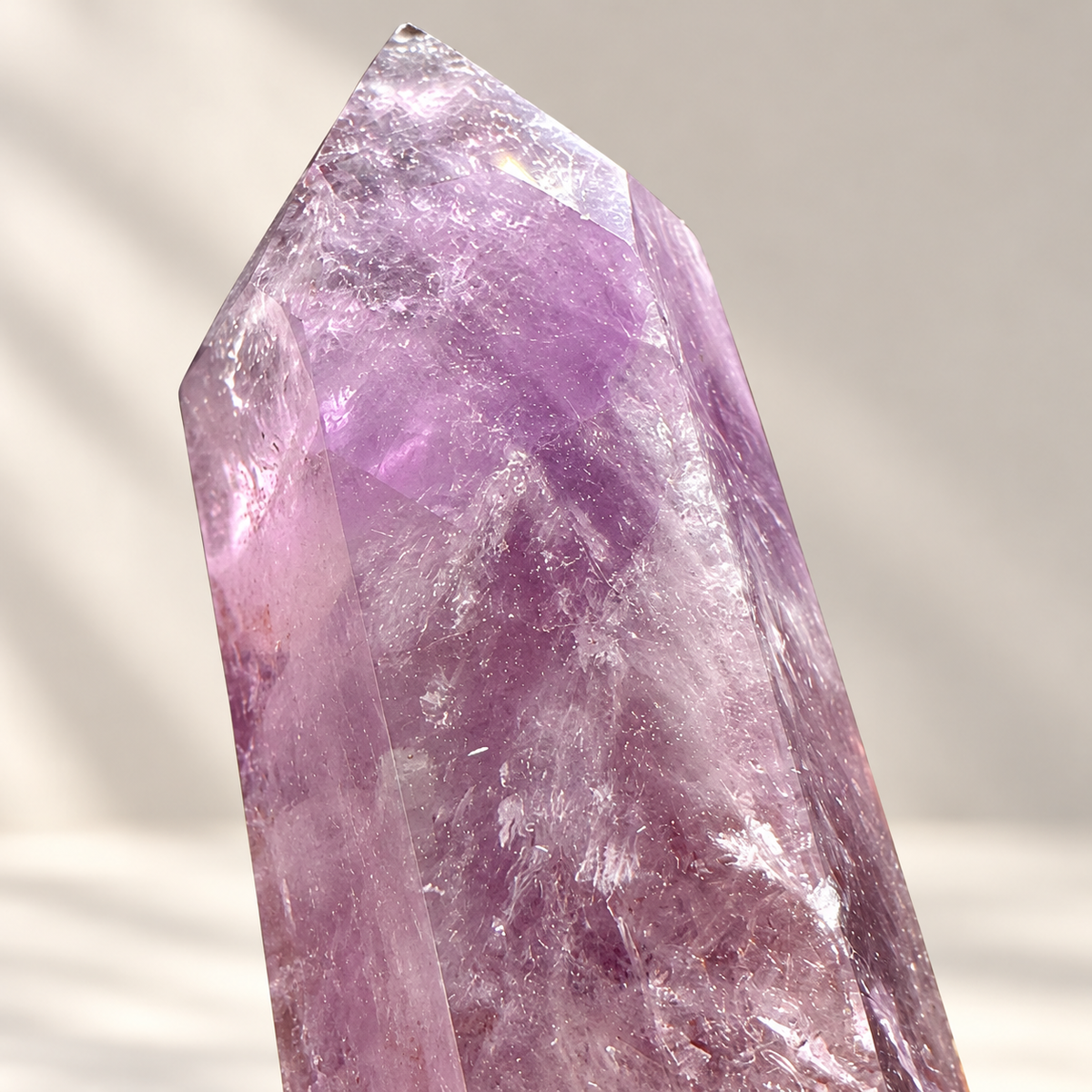Close-up of the polished point and natural internal fractures of a Brazilian Amethyst crystal tower