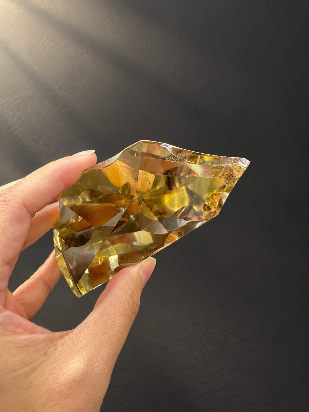 Brazilian citrine freeform No.10 held horizontally to show its faceted outline