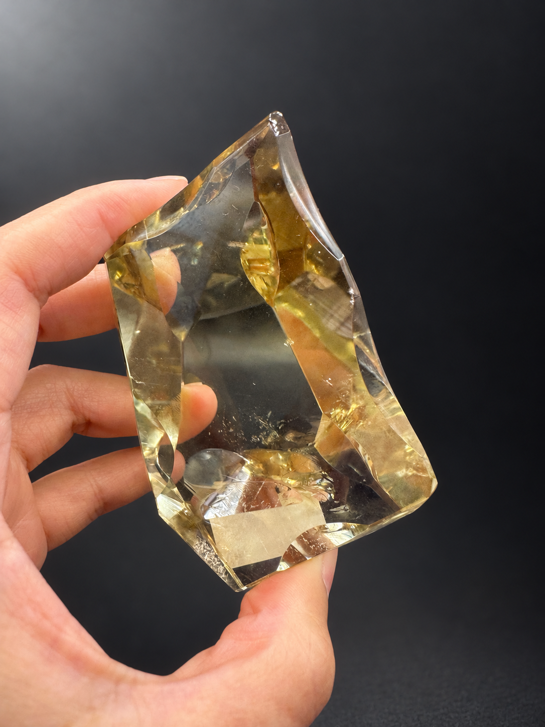Brazilian citrine No.9 held between fingers to show its asymmetric freeform outline