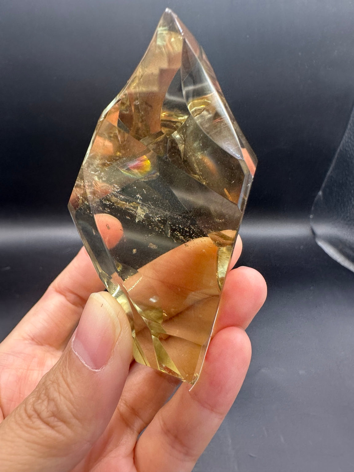 Unedited original photograph of Brazilian citrine freeform No.1, 100g, approximately 8 × 4.4cm, showing the real rainbow detail, hand grip and original background.