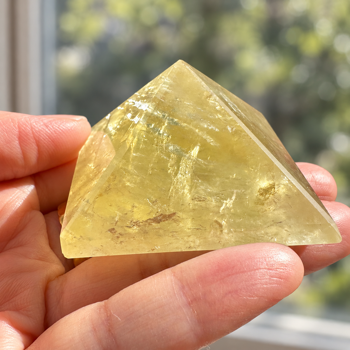 Brazilian Citrine pyramid held in a hand, showing proportions, polished faces and internal mineral textures