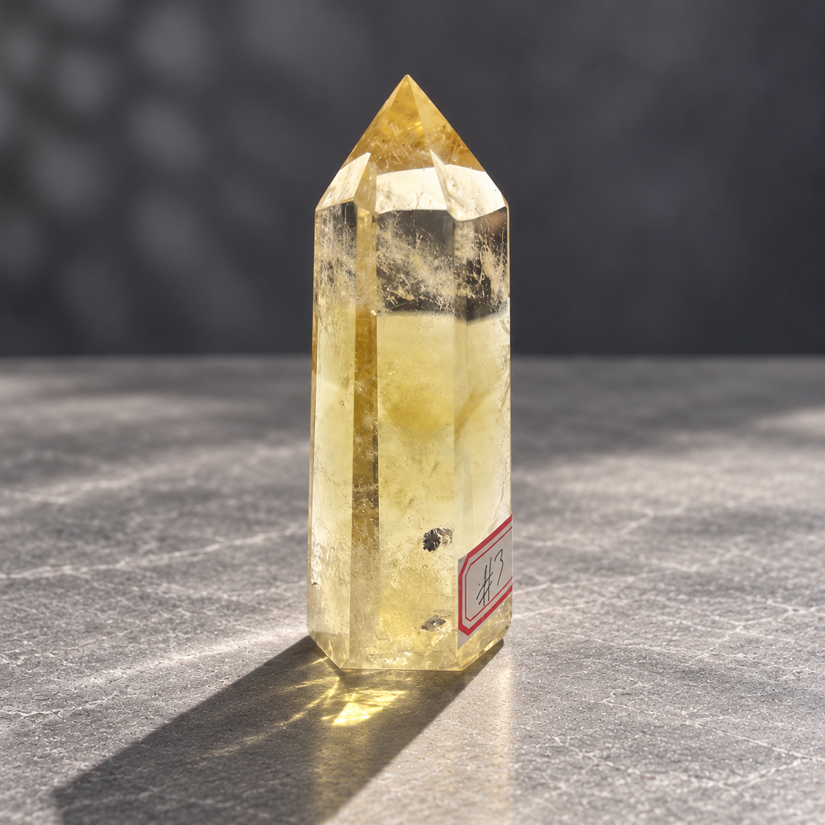 Brazilian citrine tower #3, angled view showing dark mineral inclusions in the lower body