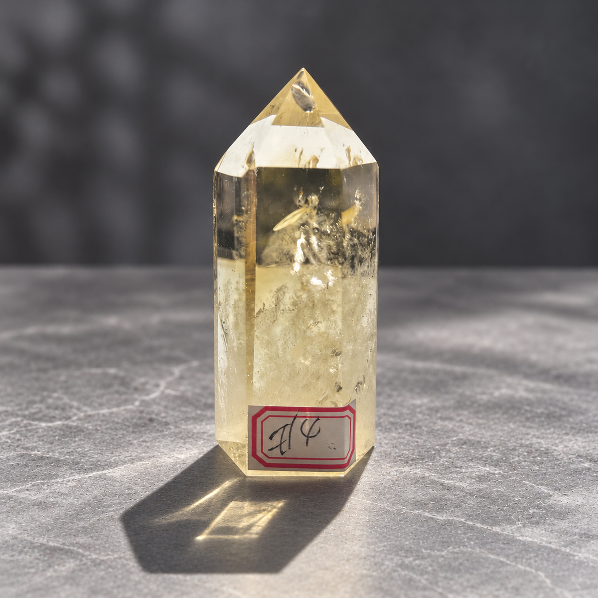 Front view of exact Brazilian citrine tower #4 showing its identifying label, polished point and natural internal textures