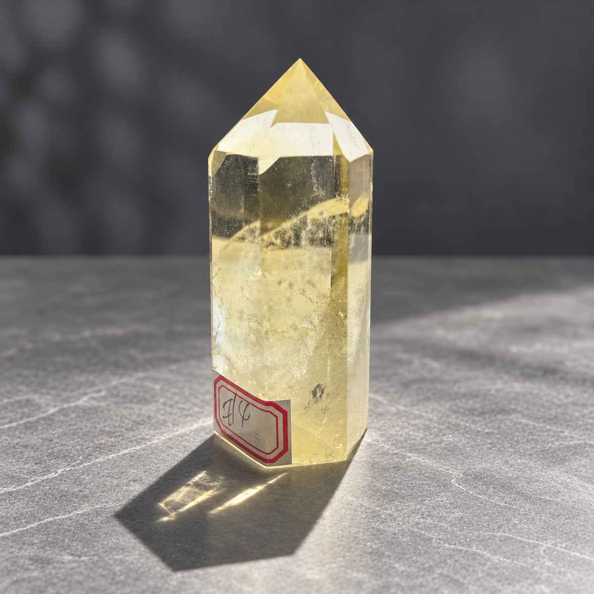 Angled view of Brazilian citrine tower #4 with transparent upper facets and a diagonal feather-like veil