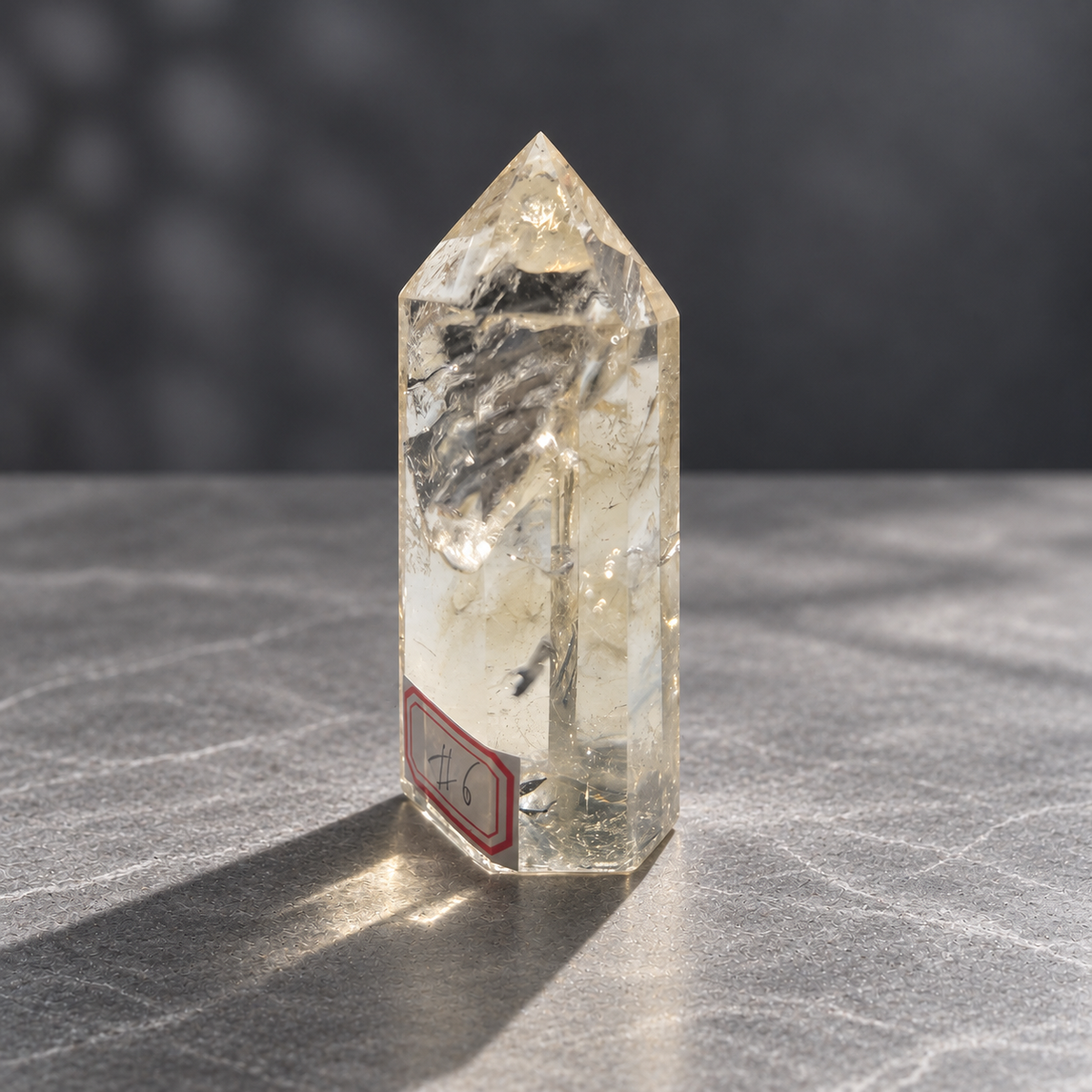 Brazilian pale yellow champagne citrine tower #6, 129g, angled front showing faceted point, clear windows and small dark inclusions