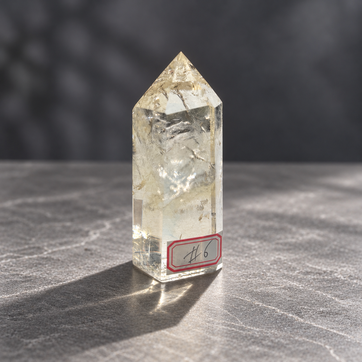 Brazilian pale yellow champagne citrine tower #6, 129g, front three-quarter view showing original number label, clear lower window and internal textures