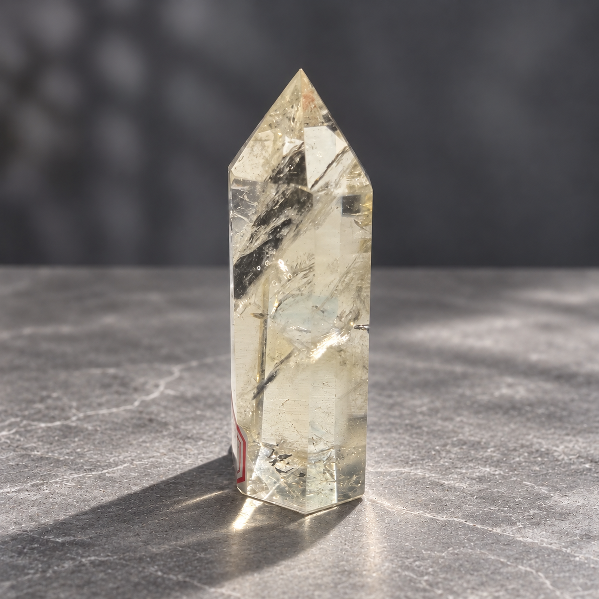 Brazilian pale yellow champagne citrine tower #6, 129g, side profile showing clear windows, diagonal veils and the original label at the edge