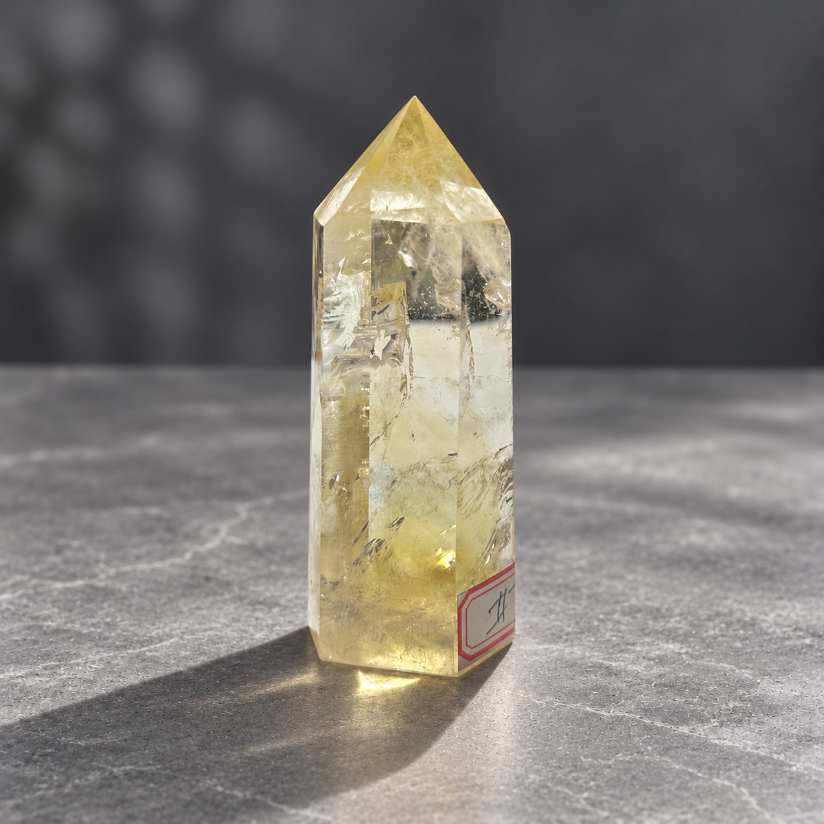 Three-quarter view of pale yellow citrine tower #7 with clear upper window and original label at edge