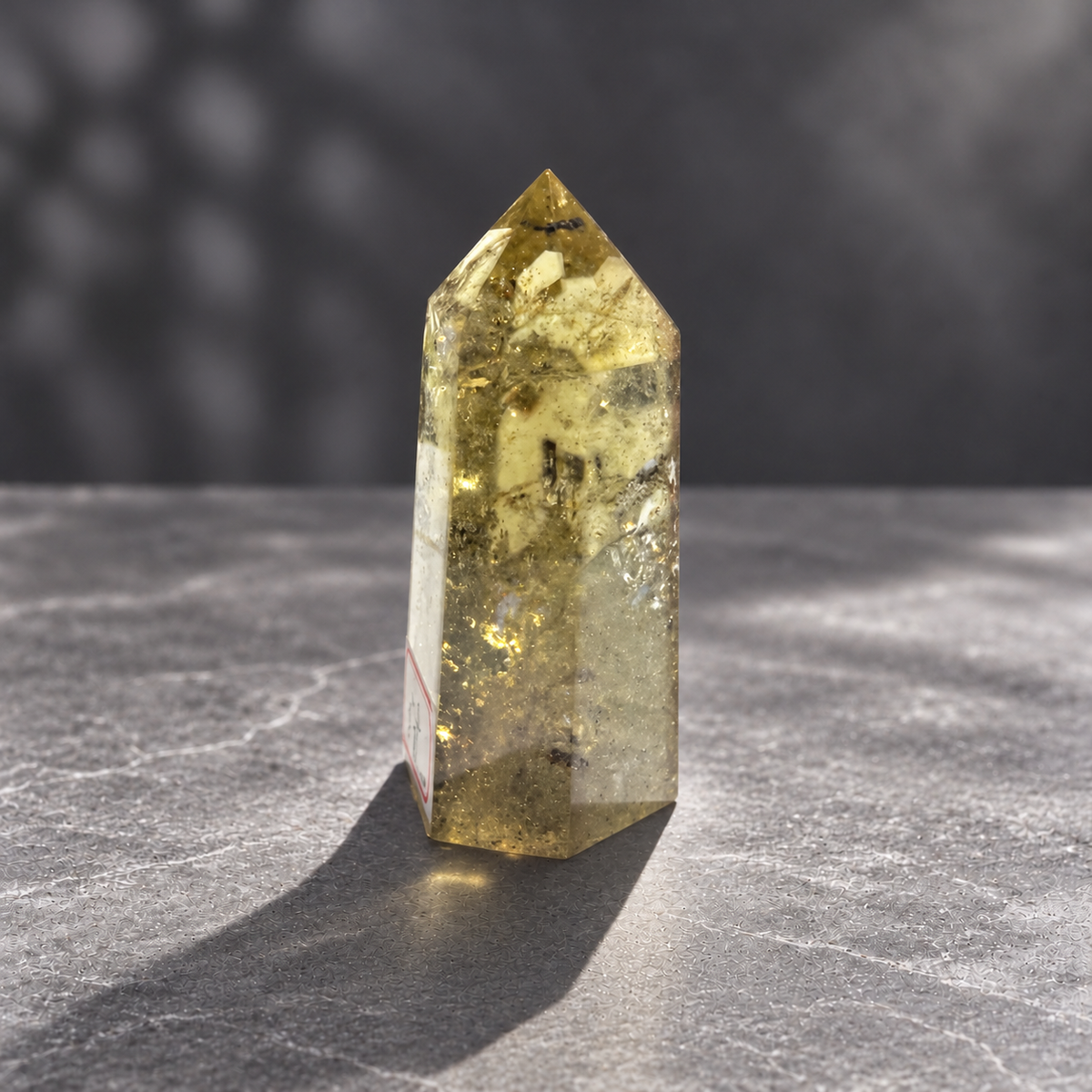 Brazilian pale yellow champagne citrine tower #8, 164g. Side view showing transparent edges, dark inclusions and reflective fracture planes
