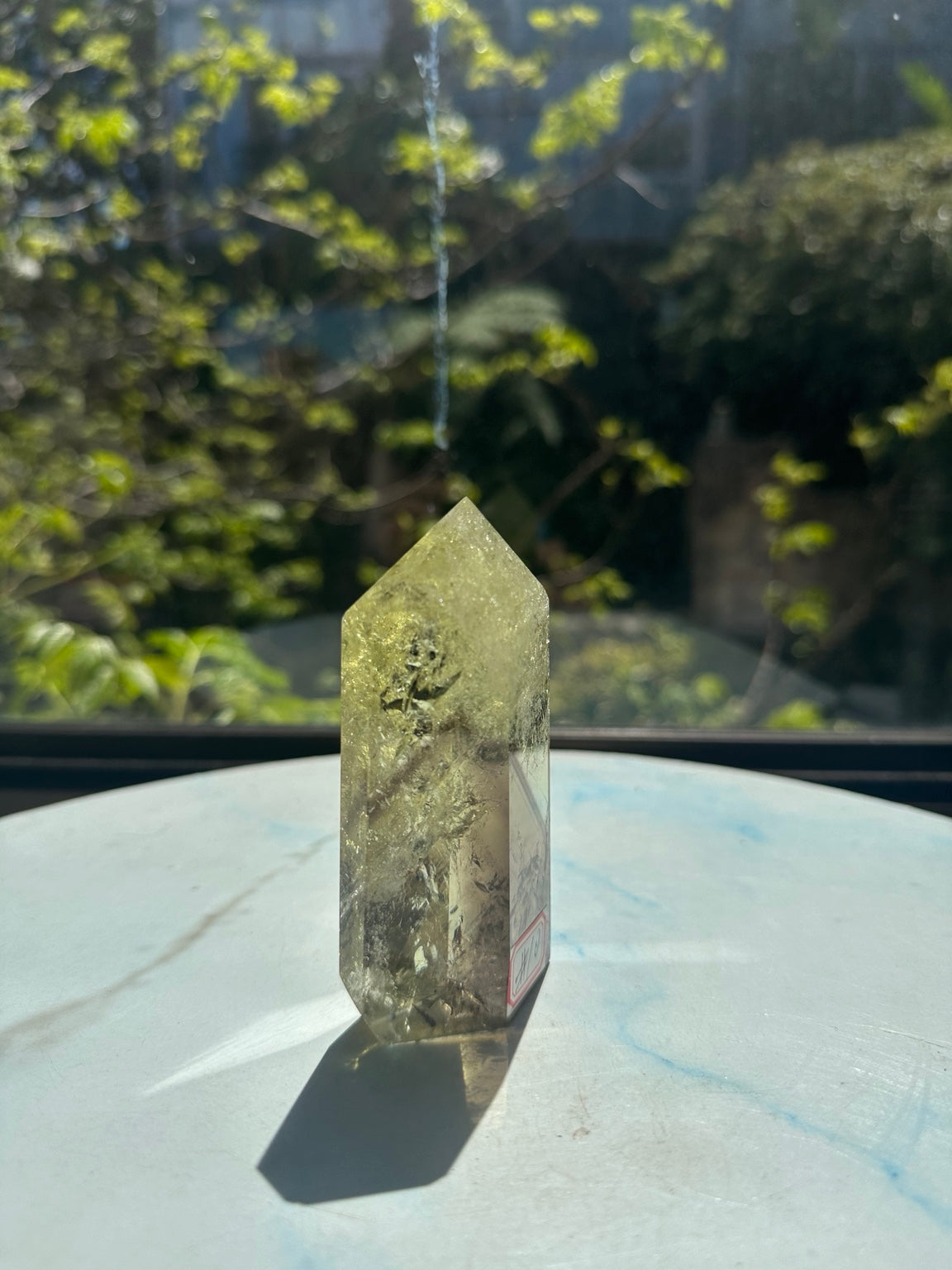 Original sunlight photograph 3 of exact Brazilian citrine tower #10, pale yellow champagne quartz showing natural fine veils, darker internal planes and polished facets.