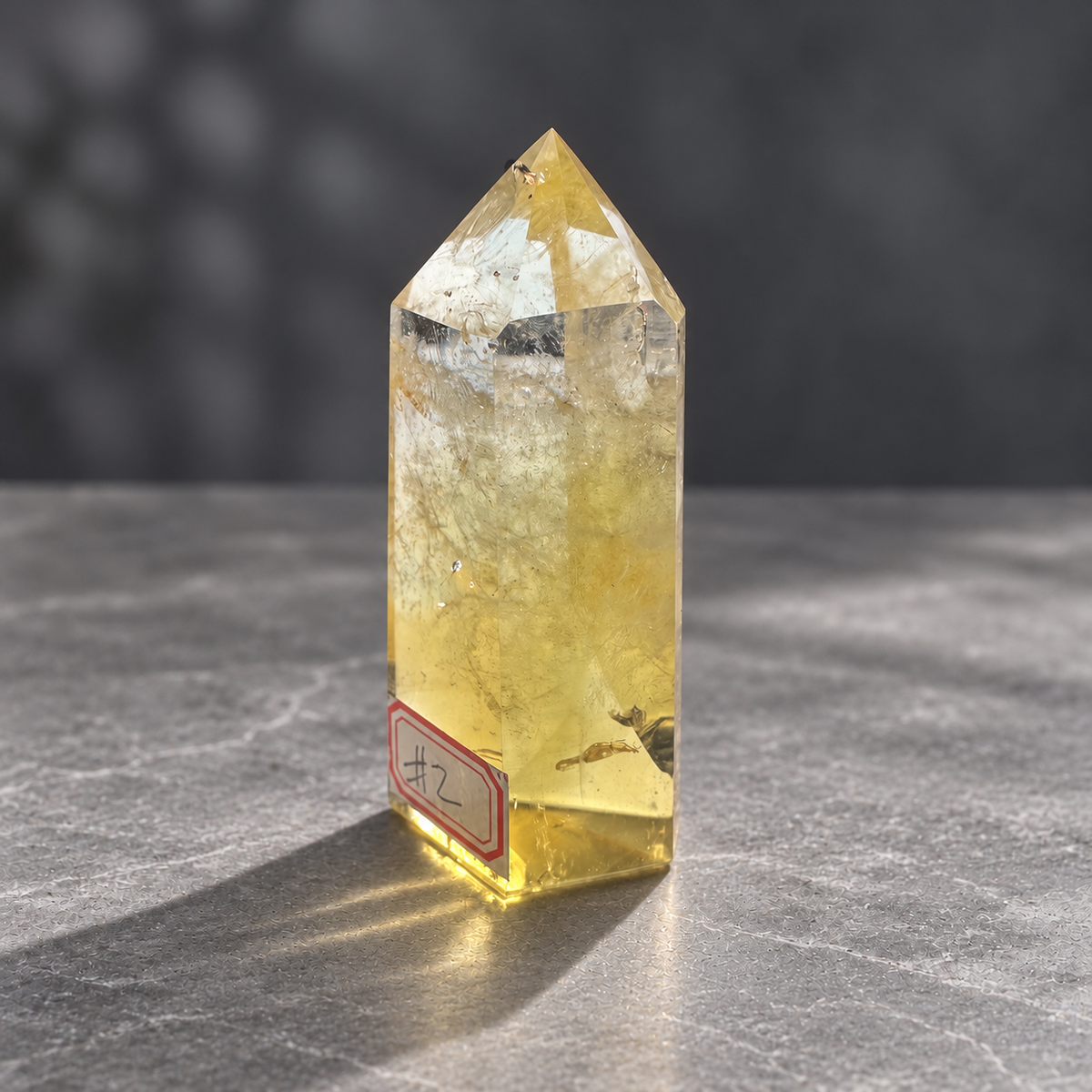 Brazilian citrine tower #2, 151g, front angle view of a pale champagne-gold polished point with clear areas and natural internal veils
