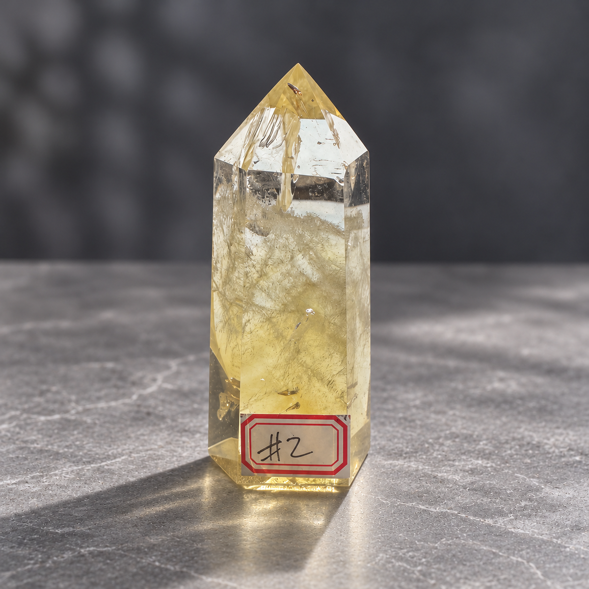 Brazilian citrine tower #2, 151g, numbered front view of a pale champagne-gold polished point with clear areas and natural internal veils