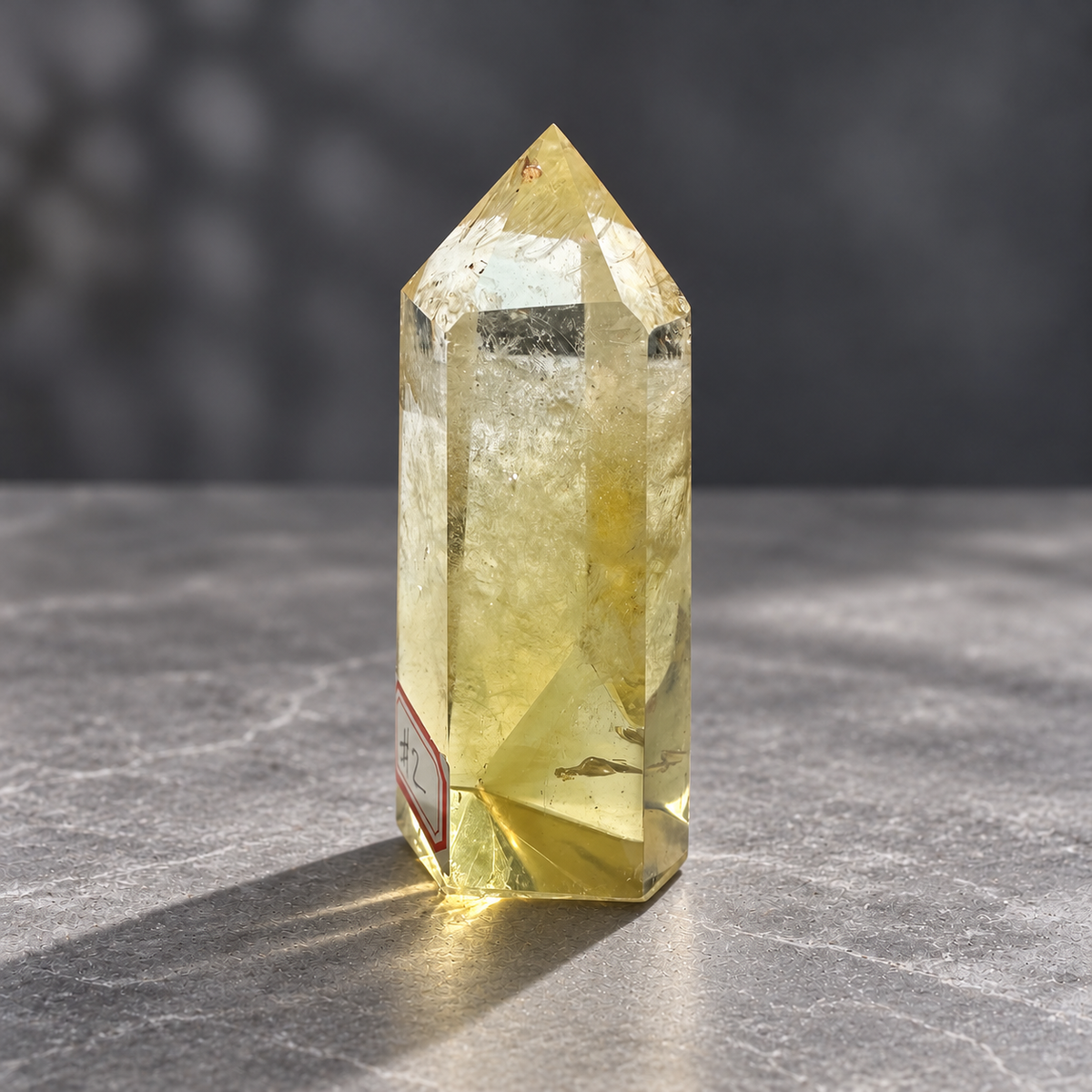 Brazilian citrine tower #2, 151g, side view of a pale champagne-gold polished point with clear areas and natural internal veils