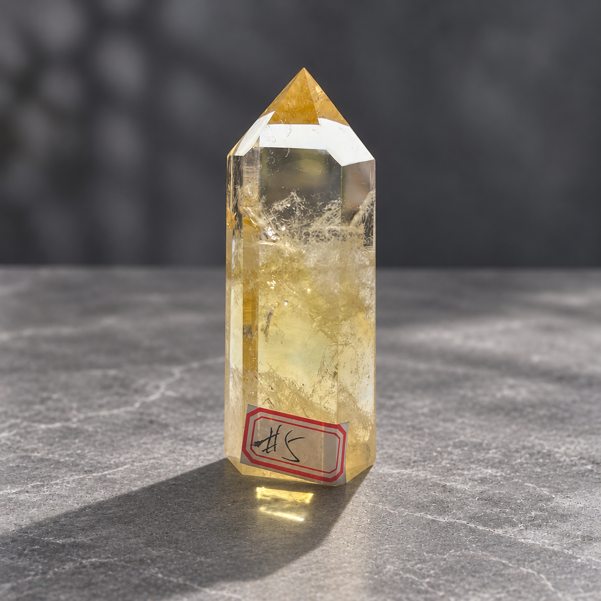 Brazilian citrine tower #5, front detail showing natural featherlike inclusions beneath the polished point