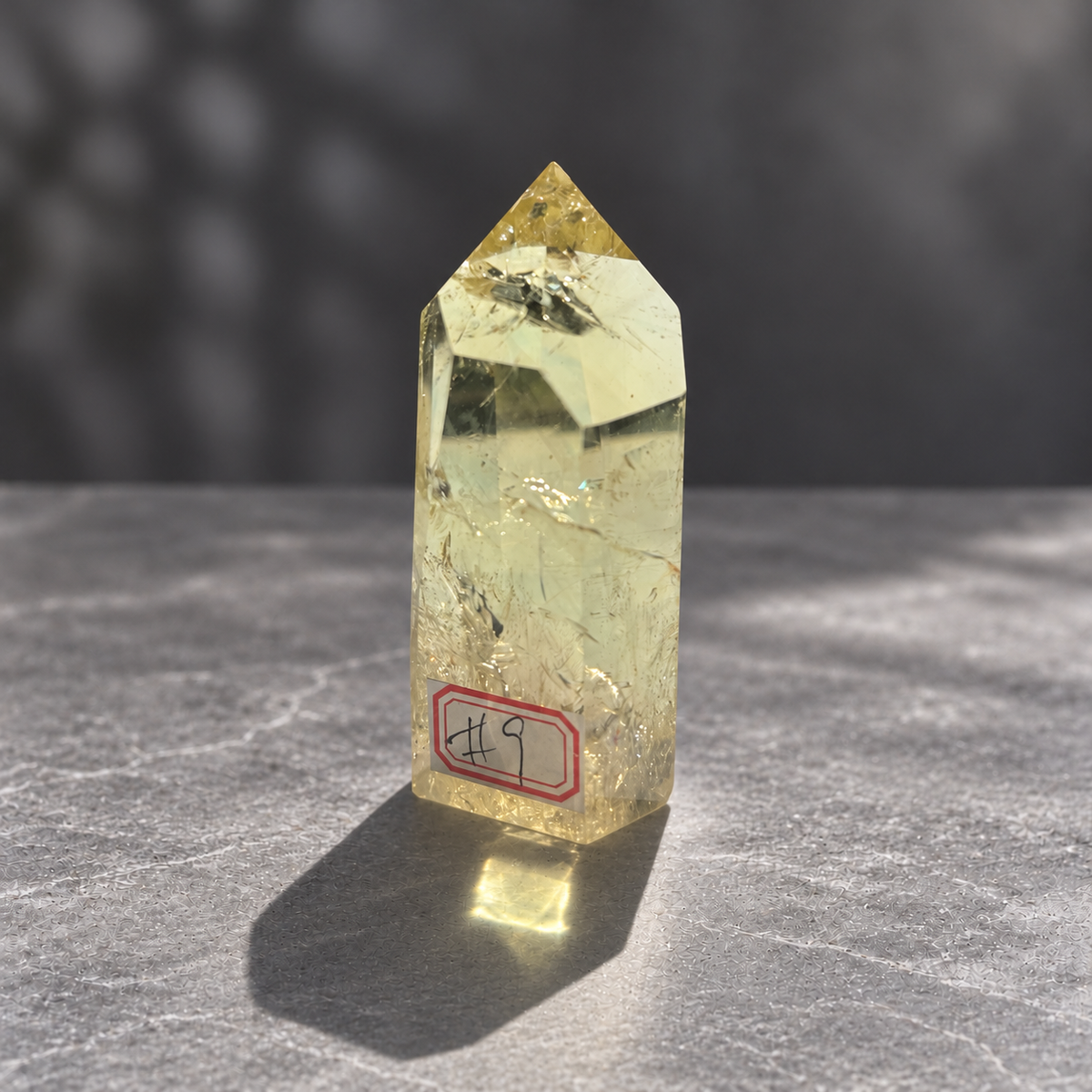 Brazilian citrine tower #9, 228g pale yellow champagne crystal point; polished specimen angle 3 with reflective internal veils and subtle darker inclusions. Exact piece photographed.
