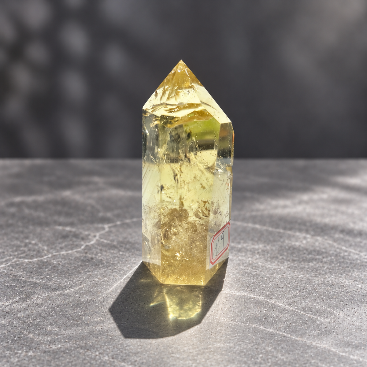 Brazilian citrine tower #9, 228g pale yellow champagne crystal point; polished specimen angle 7 with reflective internal veils and subtle darker inclusions. Exact piece photographed.