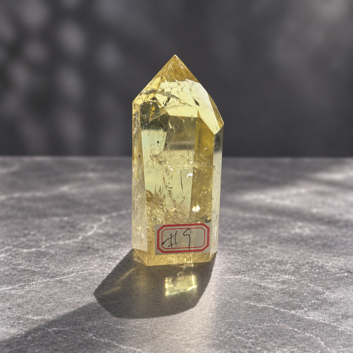 Brazilian citrine tower #9, 228g pale yellow champagne crystal point; polished specimen angle 8 with reflective internal veils and subtle darker inclusions. Exact piece photographed.
