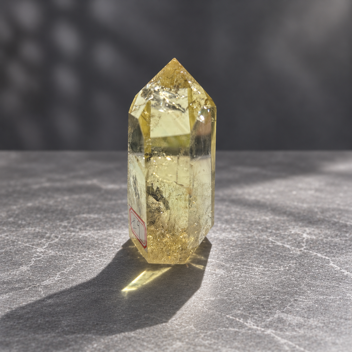 Brazilian citrine tower #9, 228g pale yellow champagne crystal point; polished specimen angle 11 with reflective internal veils and subtle darker inclusions. Exact piece photographed.