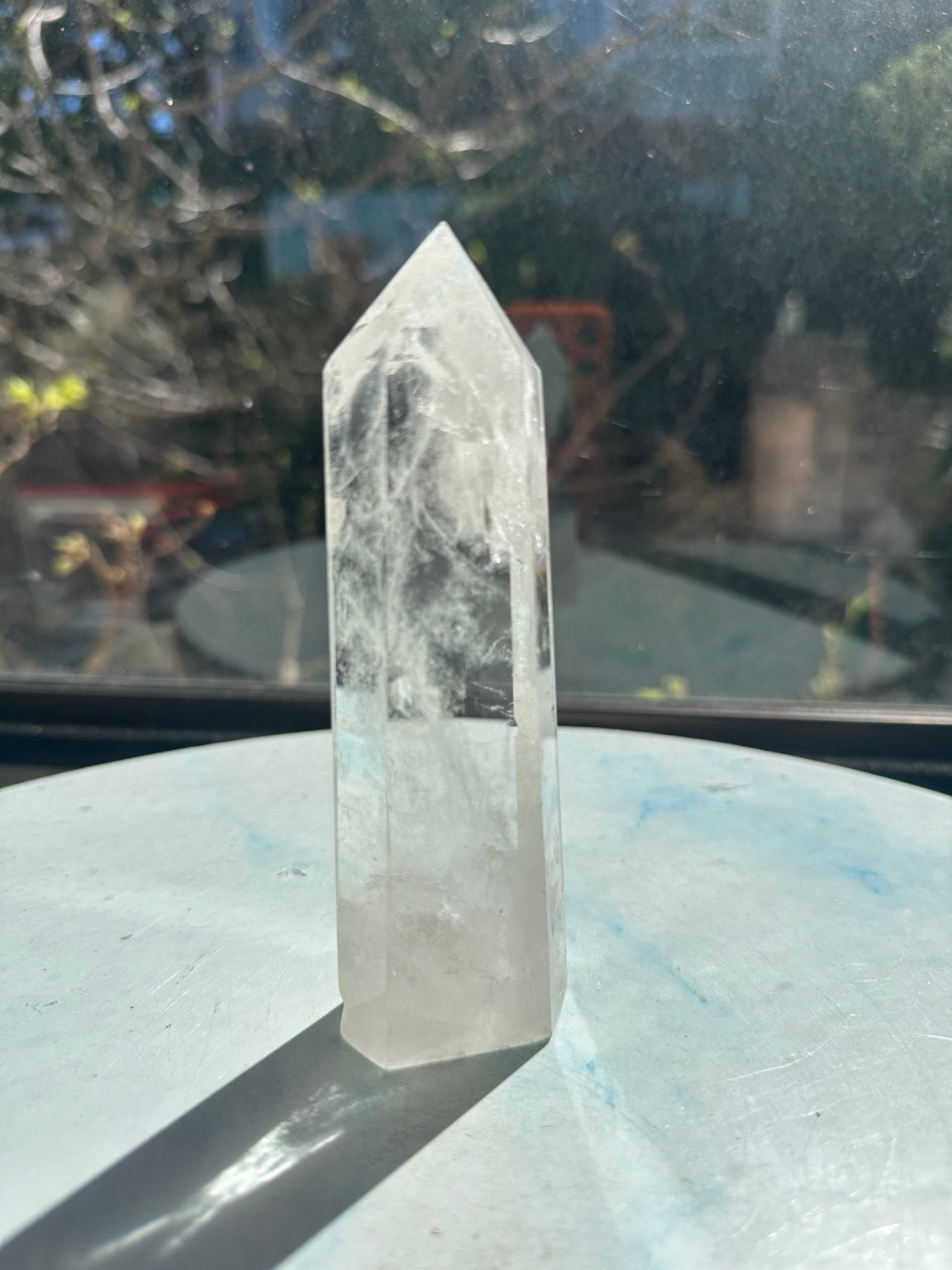 Brazilian clear quartz tower number 8, 232g and 13.2cm tall: front view without a label, with clear upper areas and wispy white veils.