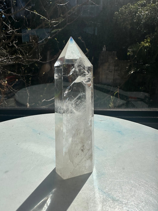 Brazilian clear quartz tower number 10, 280g and 14cm tall: unlabelled front angle showing clear upper windows and white veils toward the base.
