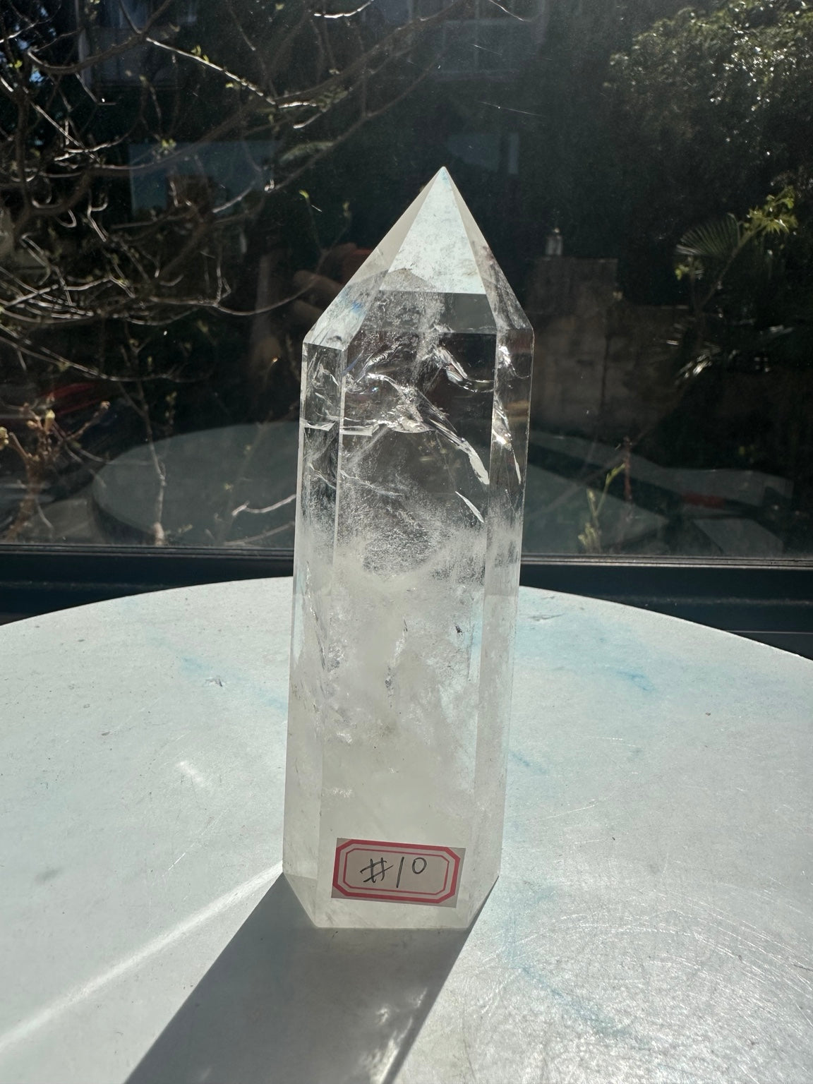 Brazilian clear quartz tower number 10, 280g and 14cm tall: front view with the number 10 identifying label near the flat base.