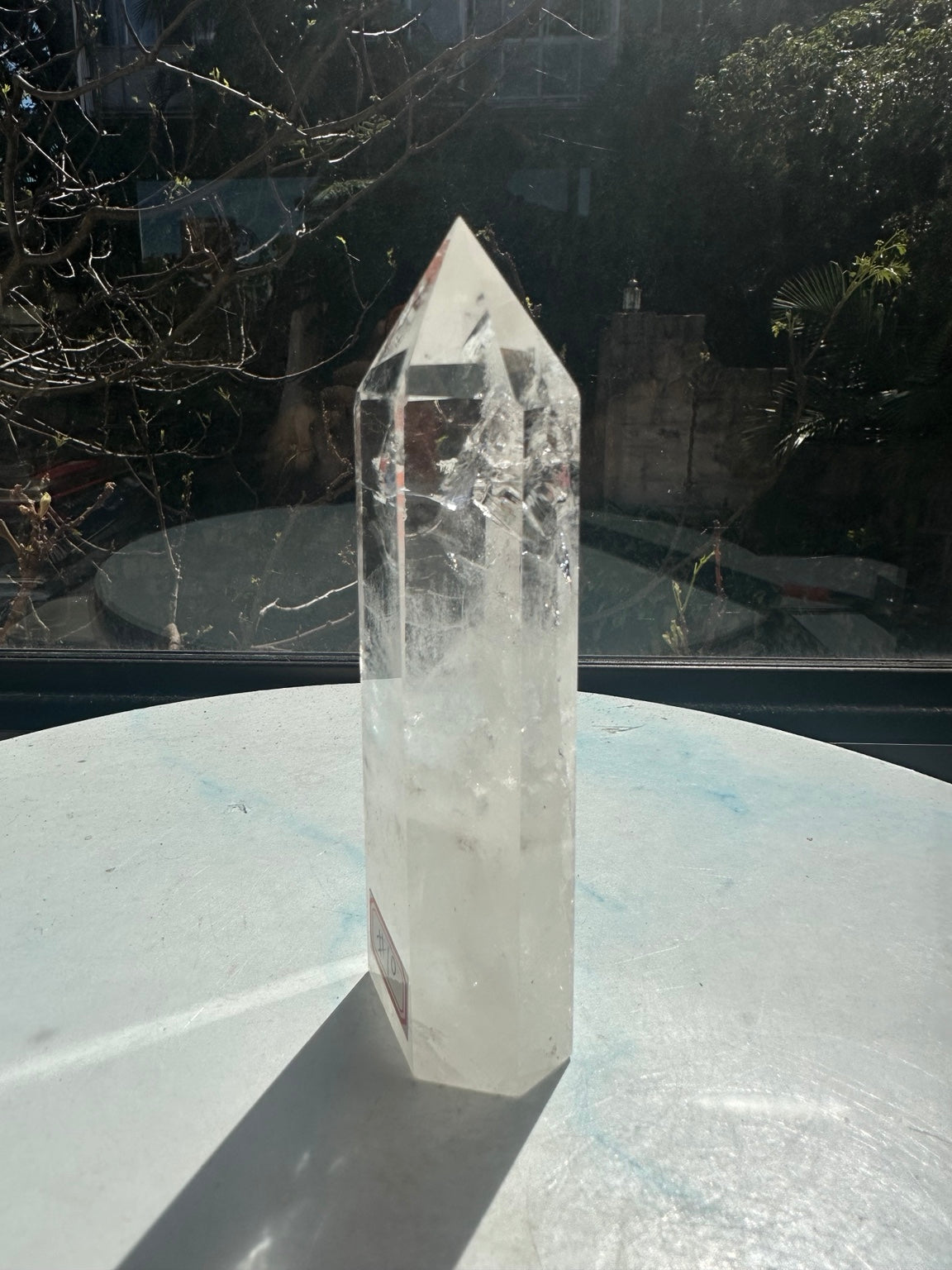 Brazilian clear quartz tower number 10, 280g and 14cm tall: narrow side view showing its slender polished shape and cloudy lower area.